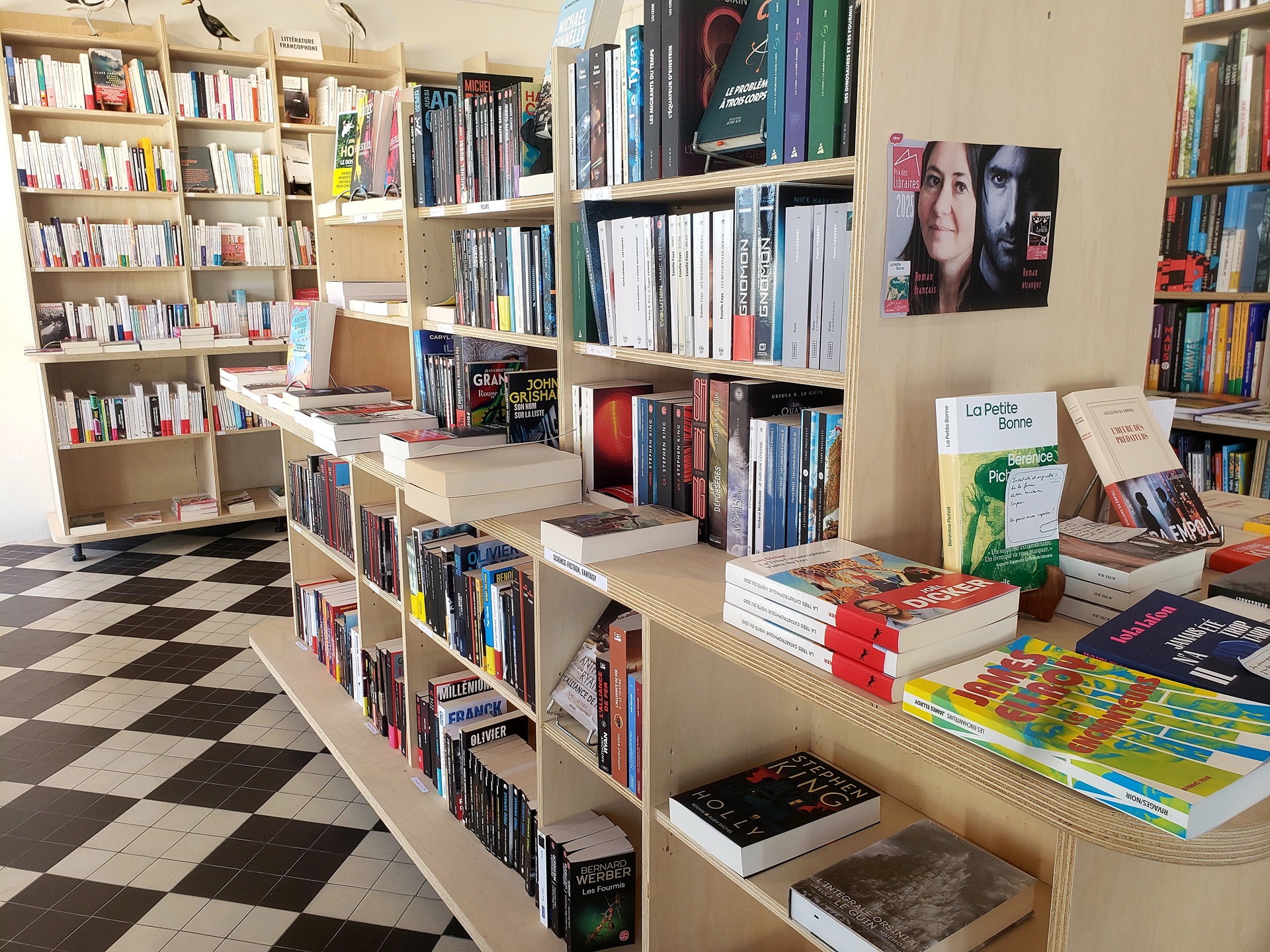 Espace intérieur dédié à une librairie, étagères, livres, carrelage noir et blanc (Gâvres, Morbihan, 56)