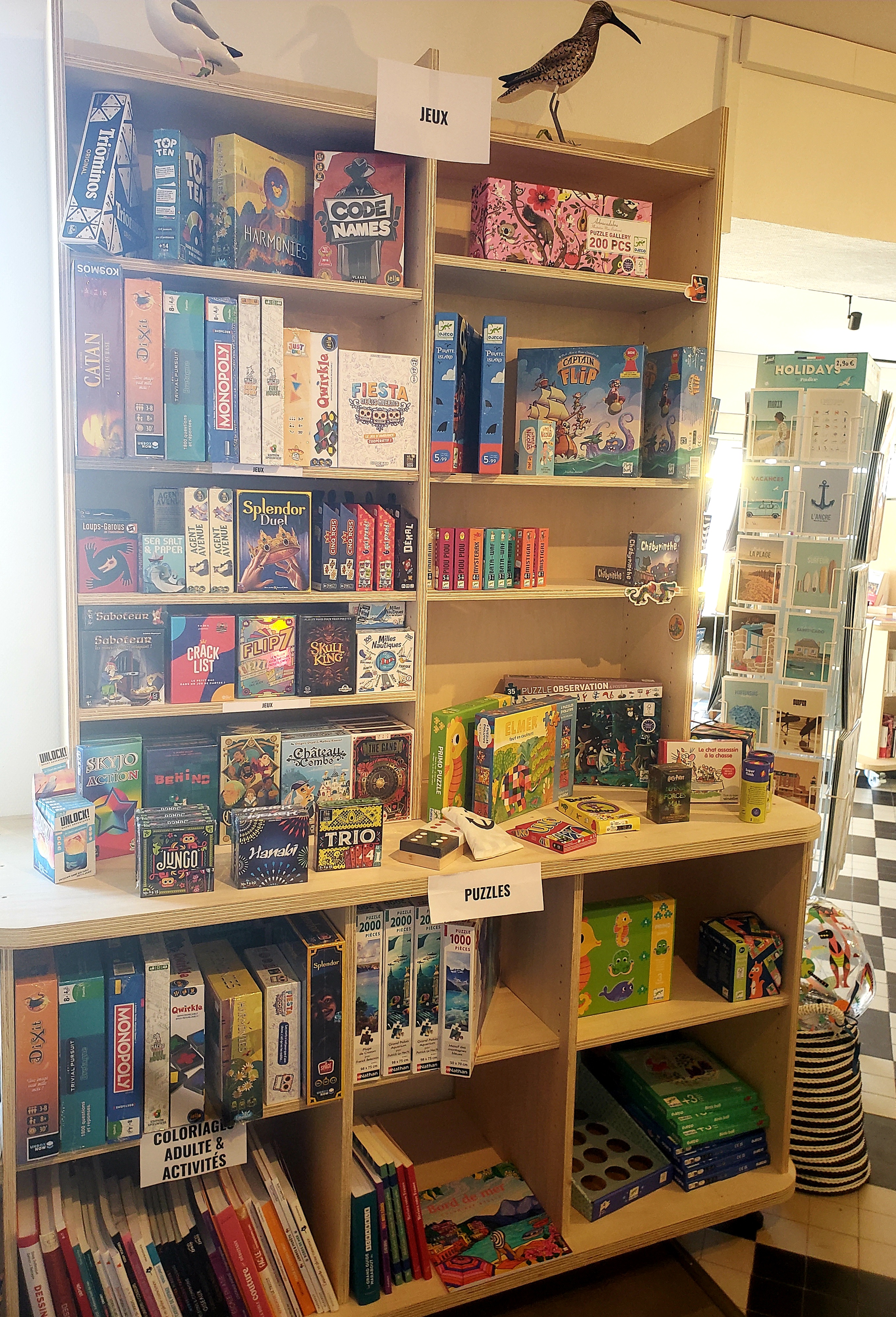 Etagère remplie de jeux de société et de puzzles utilisés lors des soirées « jeux de société » organisé par Le Comptoir Gâvrais (Gâvres, Morbihan, 56)