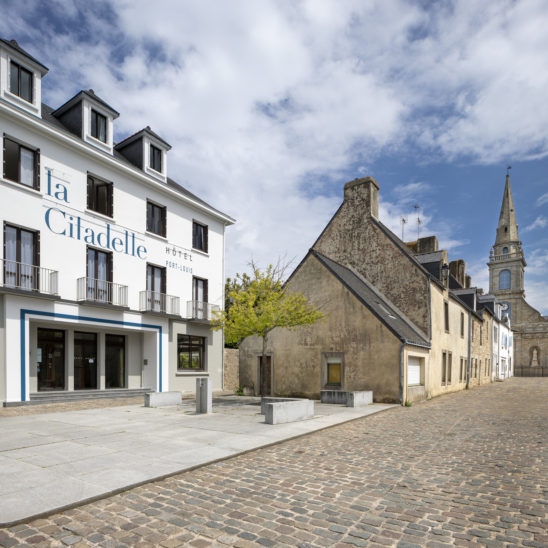 Façade de l’hôtel de la Citadelle, rue pavée et clocher (Port-Louis, Morbihan, 56)