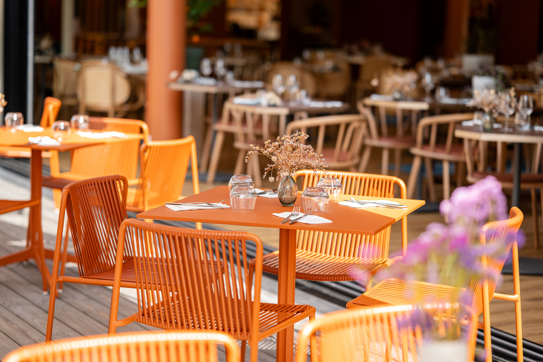 Gros plan sur la terrasse extérieure du restaurant en parquet, tables et chaises en corde (Le Bono, Morbihan, 56)