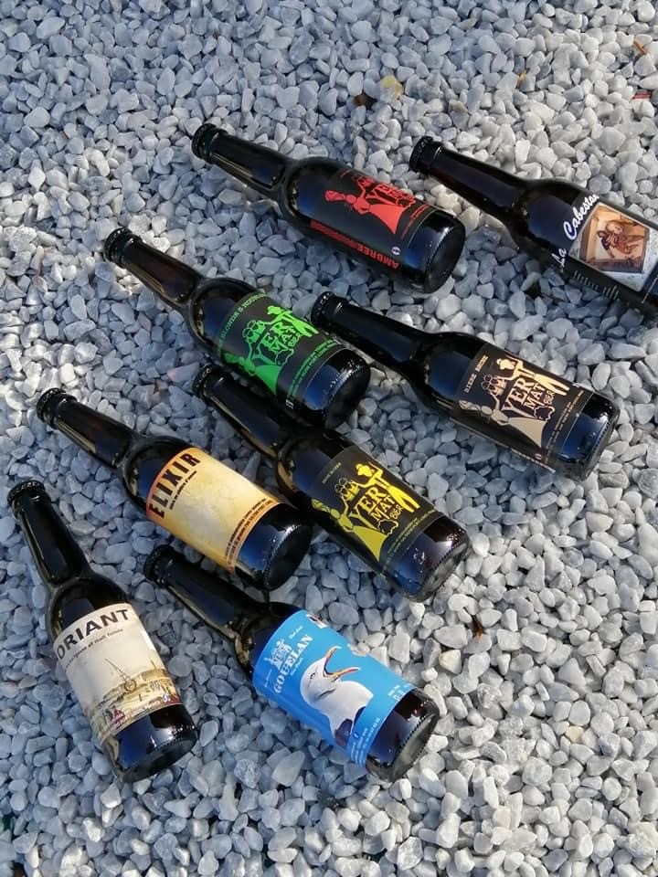 Huit types de bières différentes produites à la microbrasserie artisanale Yermat, allongées sur des gros graviers (Locmiquélic, Morbihan, 56)