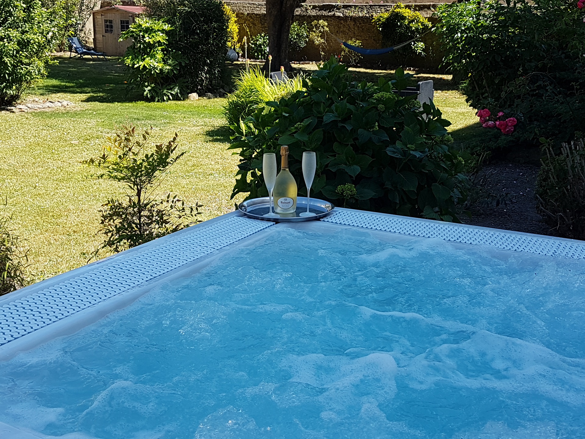 Jacuzzi dans le jardin clos de l’hôtel, plateau avec bouteille de champagne et deux flûtes givrées, Ruinart (Port-Louis, Morbihan, 56)