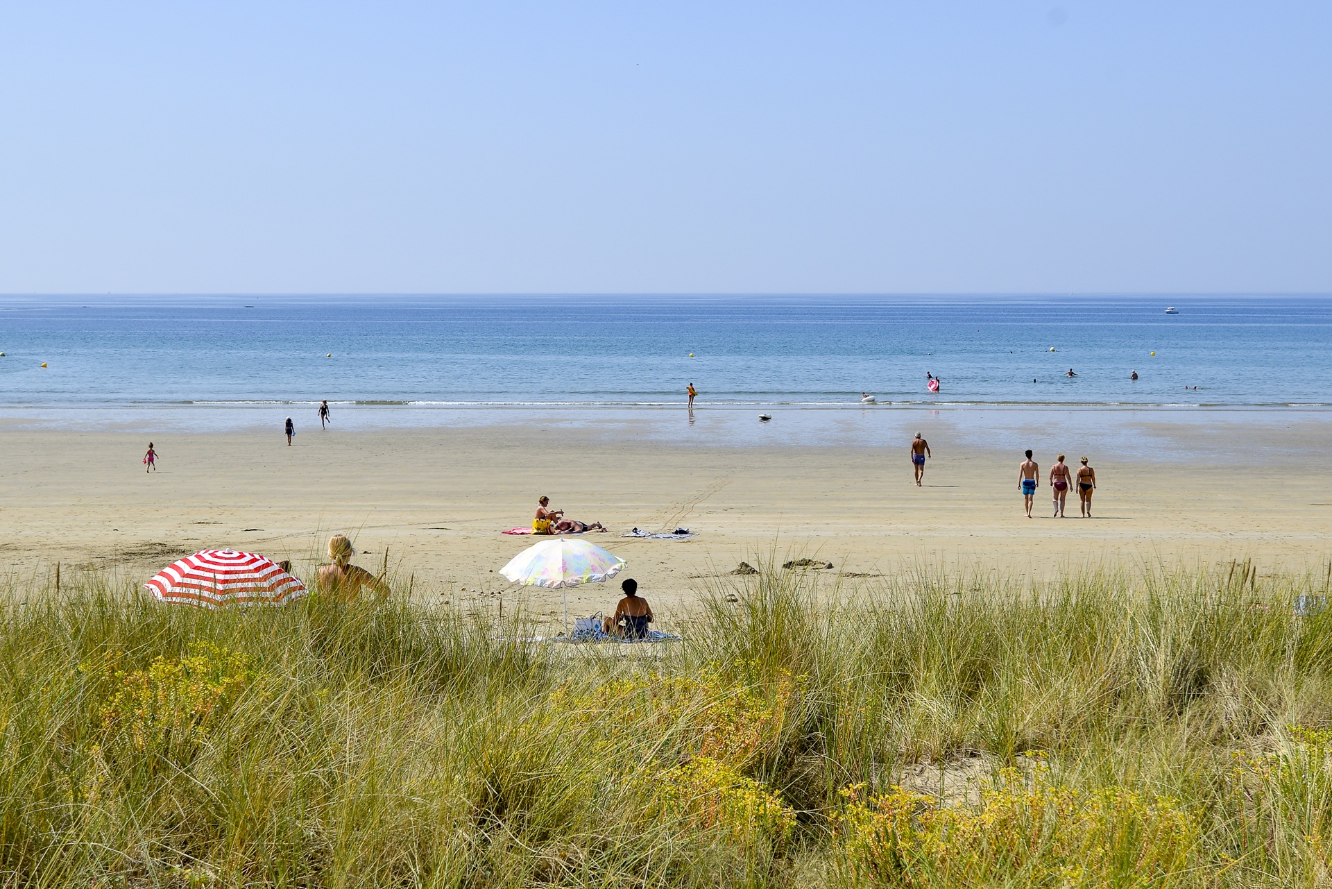 Parasols et marcheurs sur la plage du Fort Bloqué à Plœmeur (Morbihan) 56
