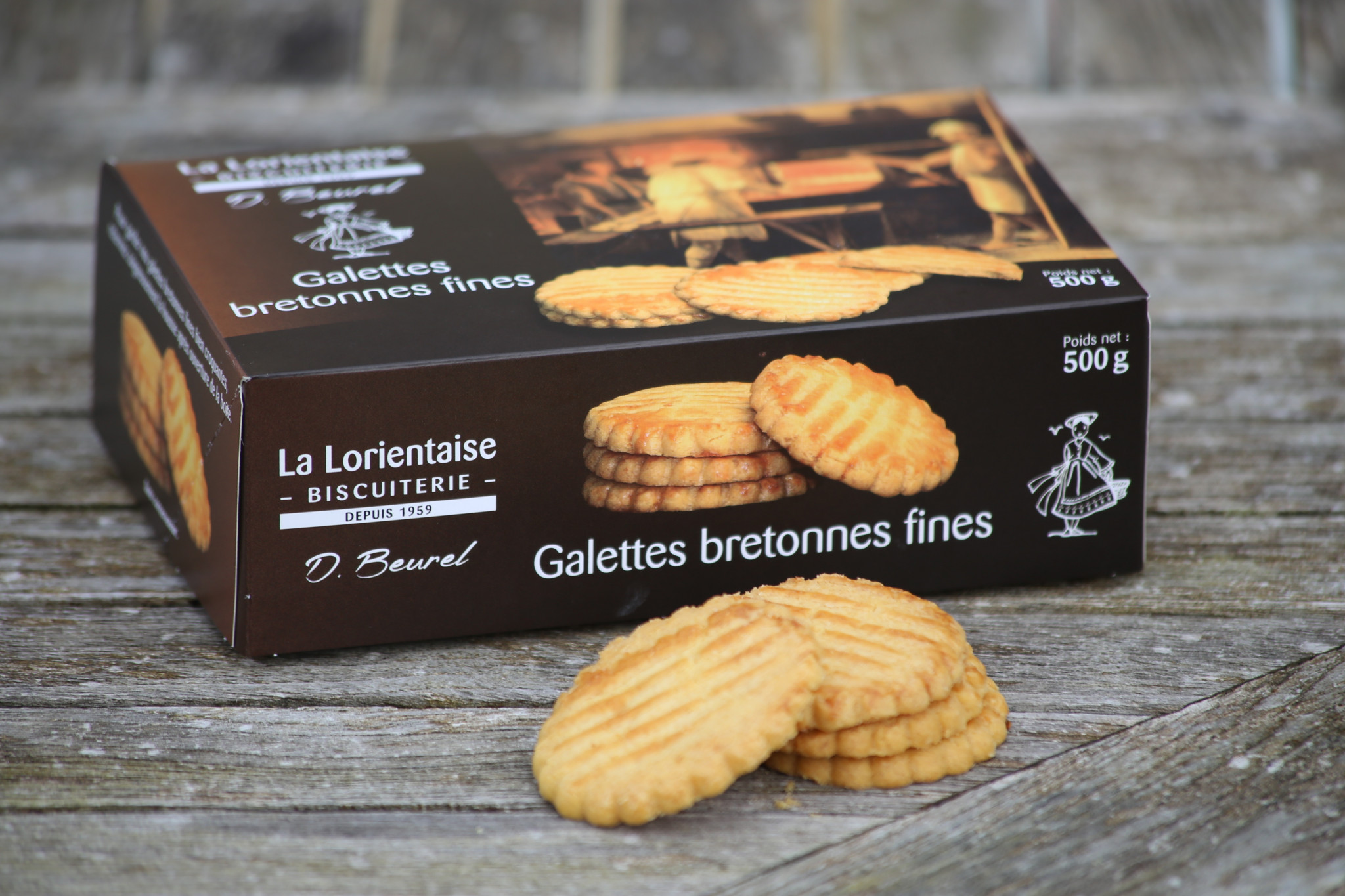 Plan serré sur une boite de galettes bretonnes fines de la biscuiterie La Lorientaise et quatre biscuits posés devant elle (Kervignac, Morbihan, 56)