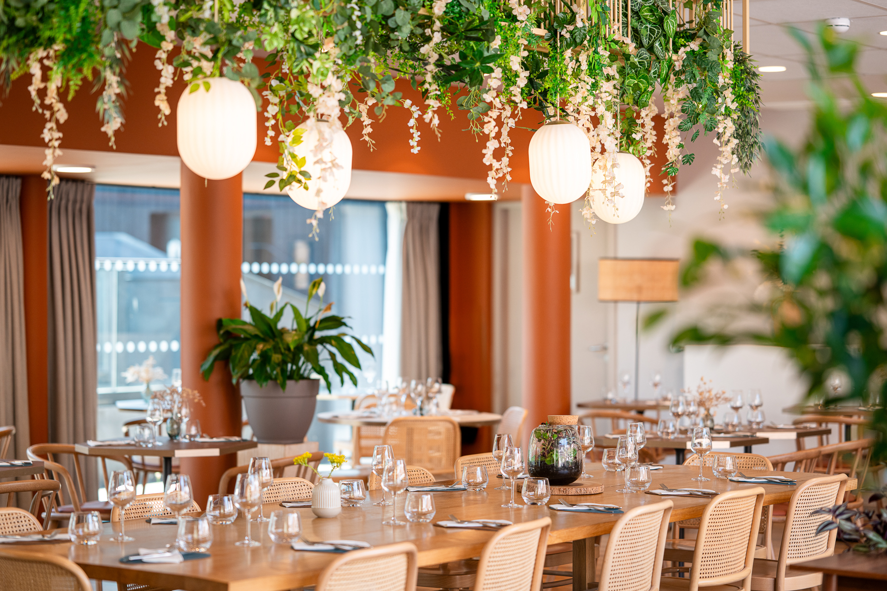 Plan serré sur une table du restaurant, décoration avec des plantes suspendues (Le Bono, Morbihan, 56)