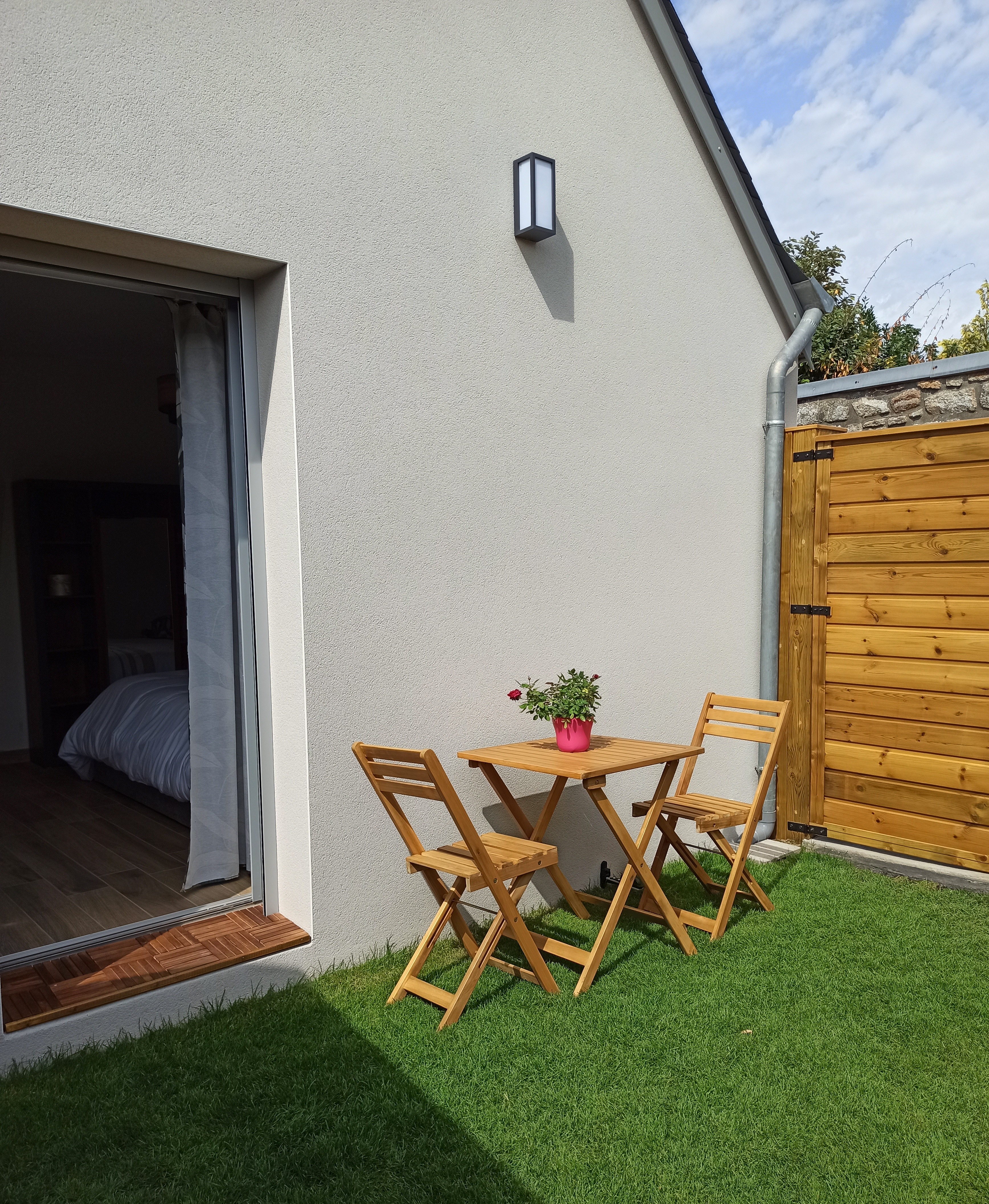 Principale – Vue sur la terrasse/jardinet, chaises et table de jardin, gazon synthétique et accès à la chambre par l’extérieur (Port-Louis, Morbihan, 56)