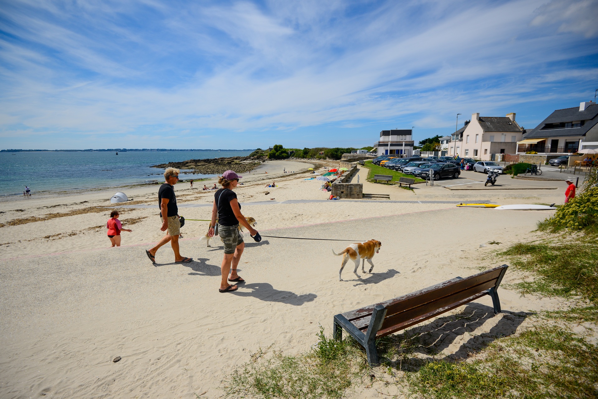 Promeneurs avec leur chien sur la promenade qui longe la plage de Locqueltas à Larmor-Plage (Morbihan)