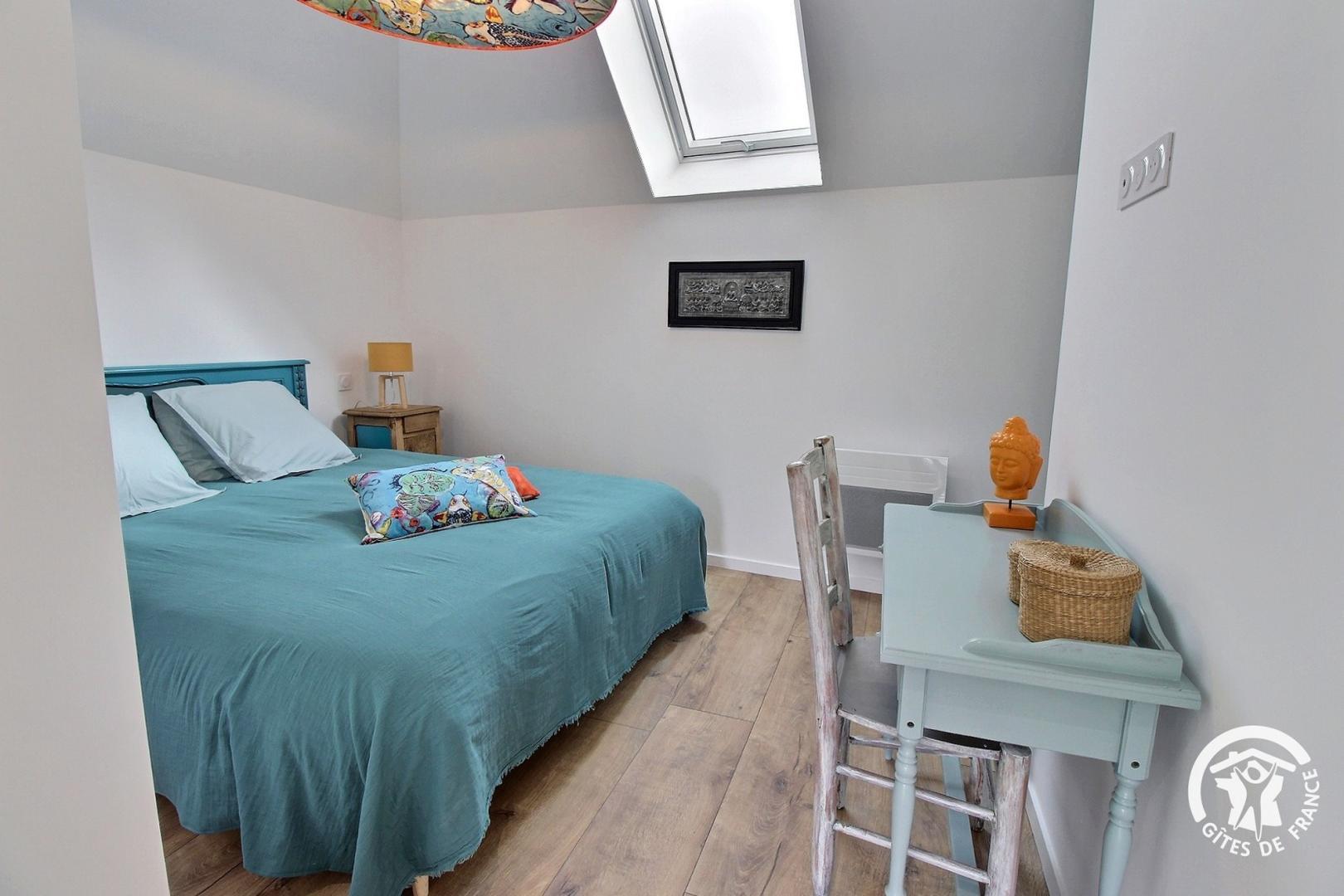Chambre dans les tons clairs, gris/blanc, située sous plafond mansardé avec velux, lit double, table et chaise, décoration bouddha (Sainte-Hélène, Morbihan, 56)