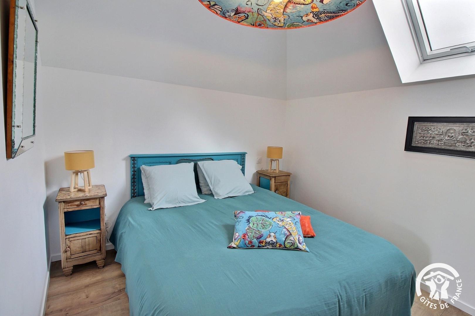 Chambre dans les tons clairs, gris/blanc, située sous plafond mansardé avec velux, lit double, tables et lampes de chevet, décoration asiatique (Sainte-Hélène, Morbihan, 56)