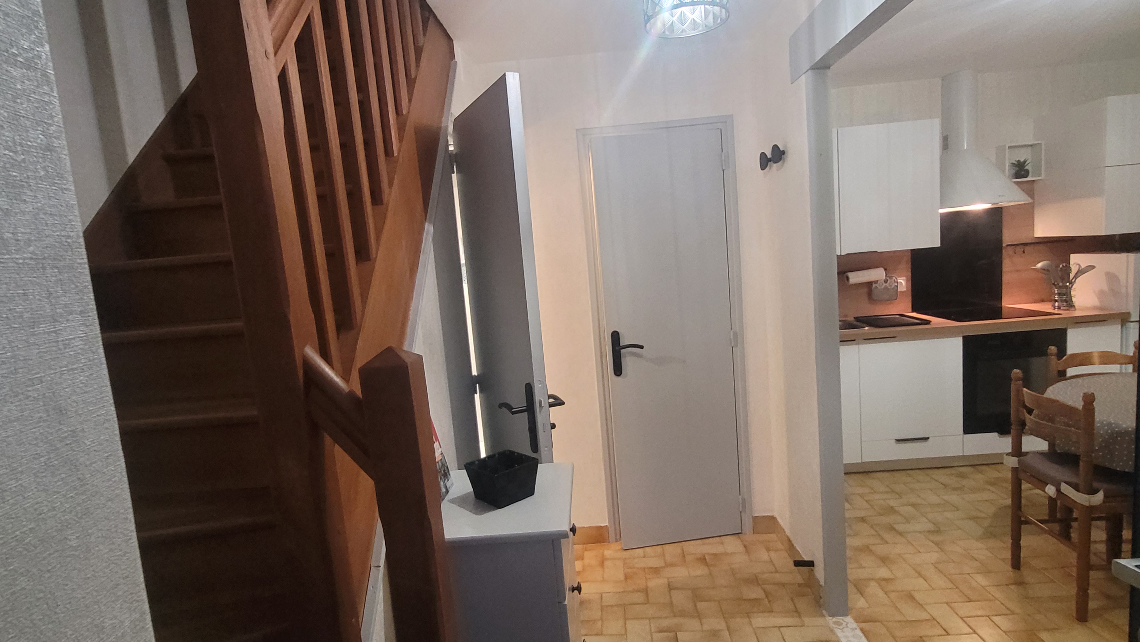 Vue sur la cuisine, la salle à manger et l’escalier menant à l’étage dans le gîte (Merlevenez, Morbihan, 56)